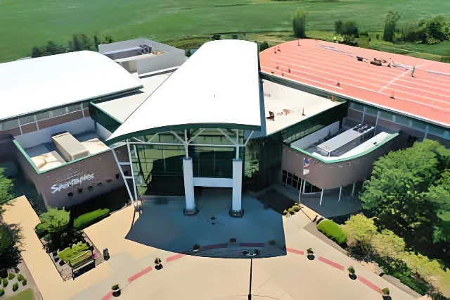 Aerial view of a large commercial building with white and red roof sections